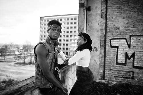 black and white image of young people standing in front of urban graffiti